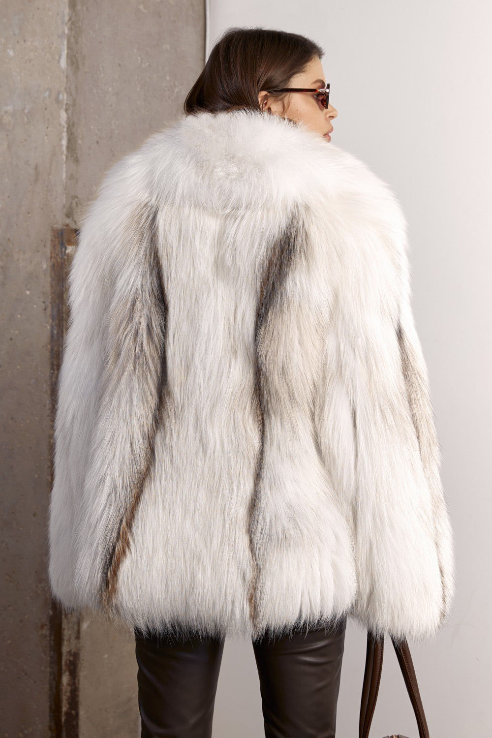 A woman wearing a high-end oversized white fox fur coat, crafted for both comfort and sophistication, with radiant natural tones and a flowing fit.