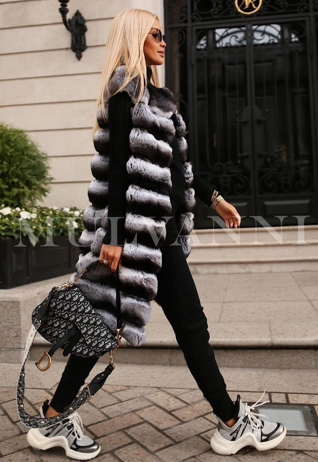 A woman wearing a stylish Rex fur midi vest that exudes elegance and warmth. The vest's luxurious texture and flattering length elevate her outfit for a chic winter look.