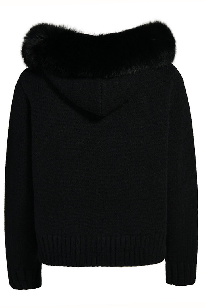 Chic black cashmere outerwear with plush fox fur details, blending comfort with sophistication.