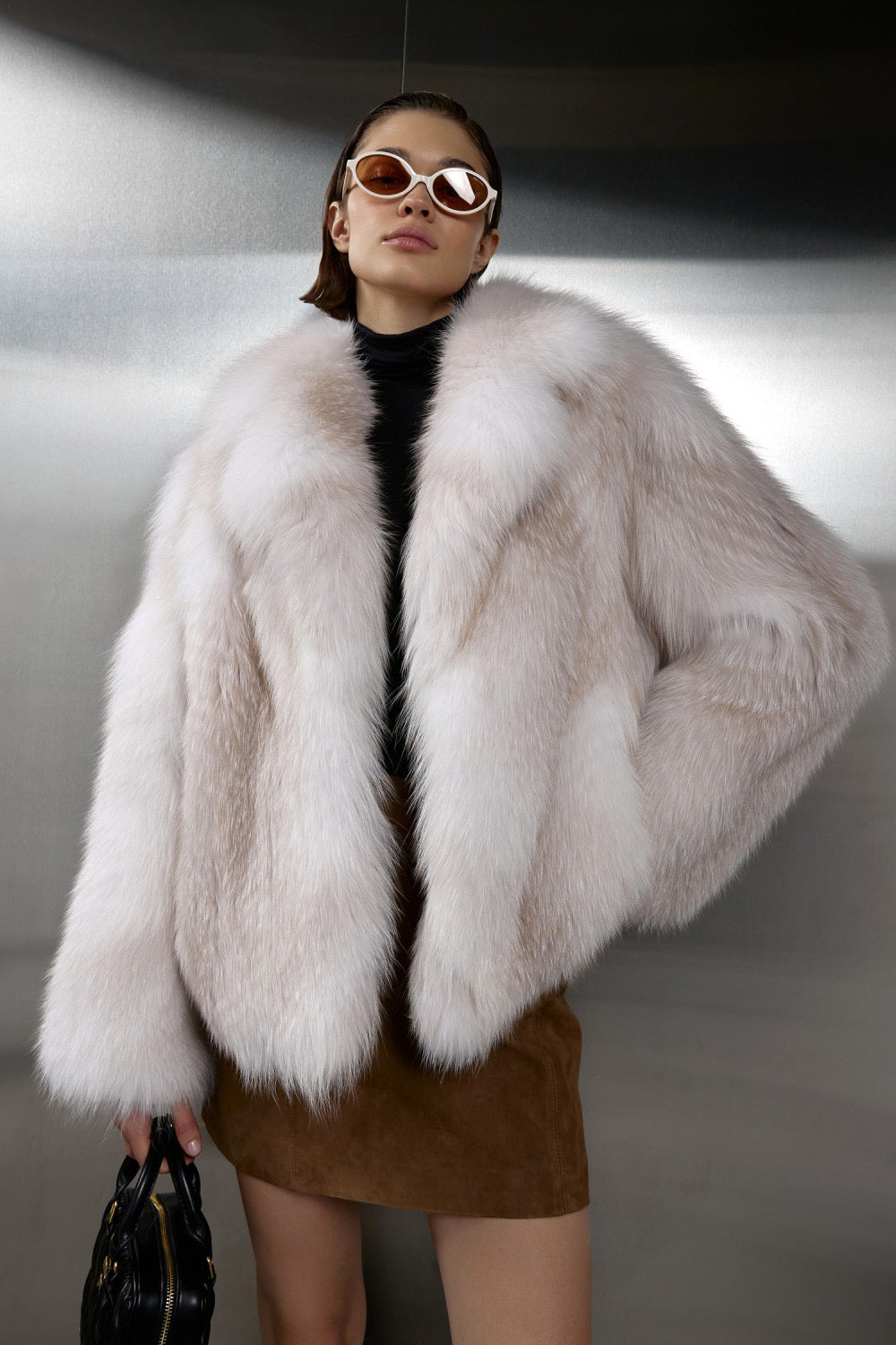 Elegantly dressed, a woman models a luxurious Crossed Fox Fur coat that combines opulent warmth with sophisticated style.