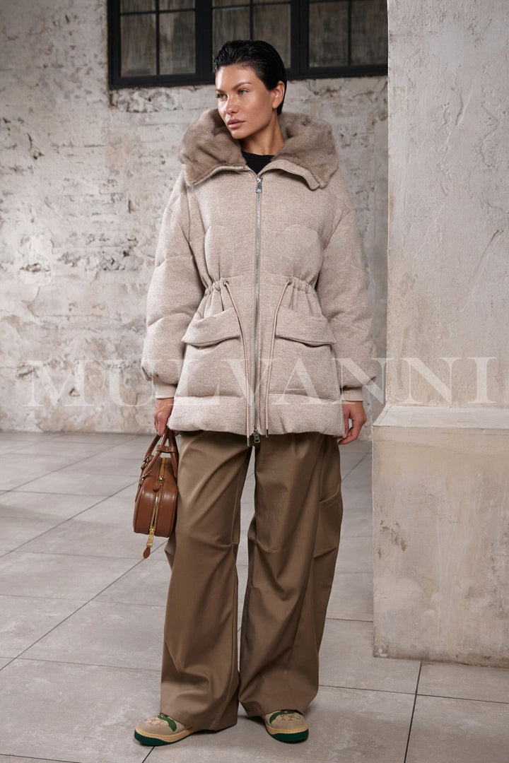 Close-up of a woman wearing the reversible down jacket, highlighting the sumptuous mink fur trim and updated drawstring detail.