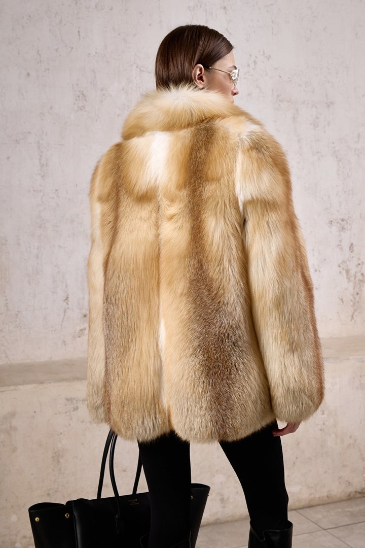 A woman models a show-stopping gold fox fur coat and sunglasses, tailored for both luxury and practicality in freezing weather, offering elite comfort and enduring style.