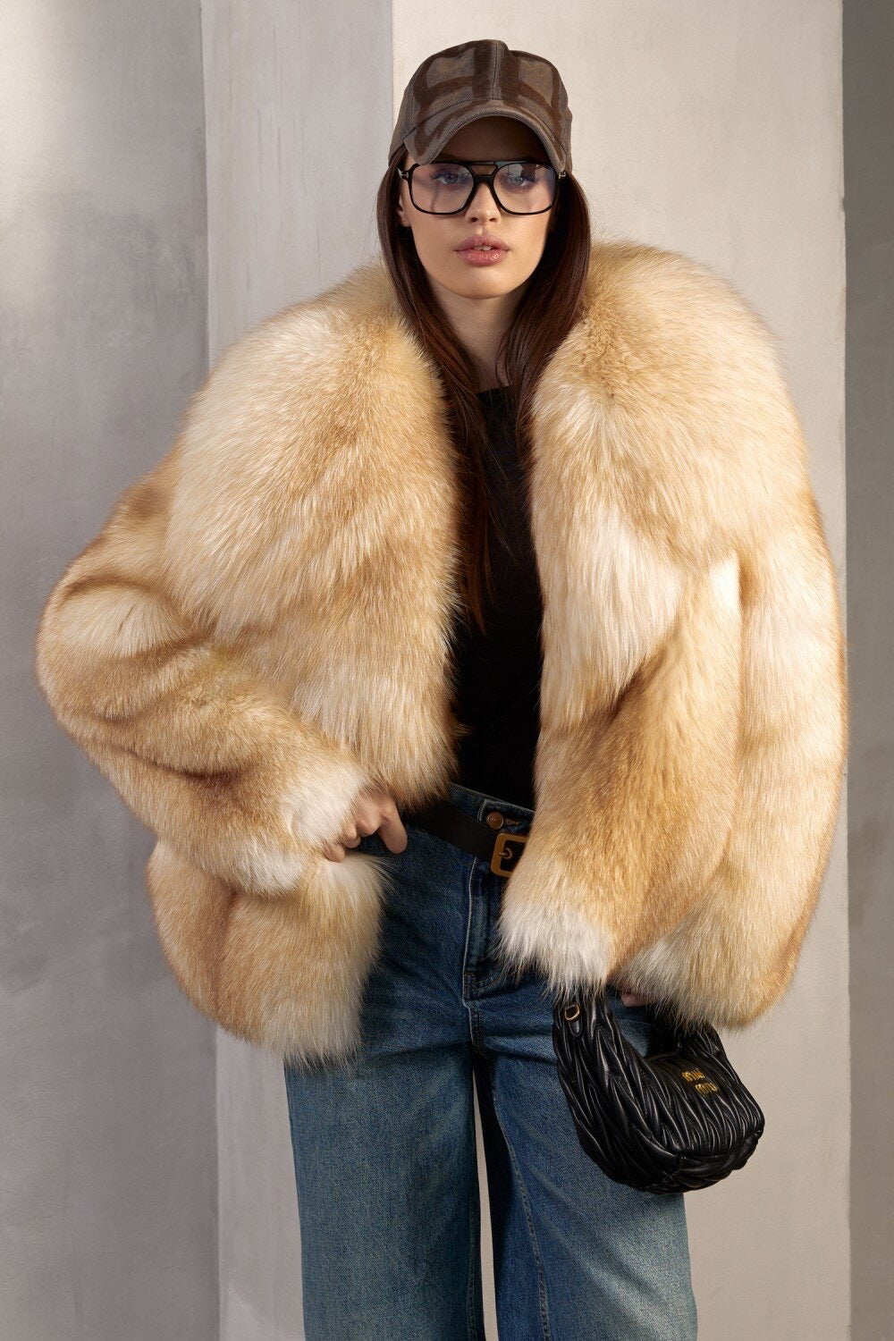A woman wearing a full pelt gold fox fur coat, showcasing its bold and luxurious texture, perfect for making a refined winter statement.