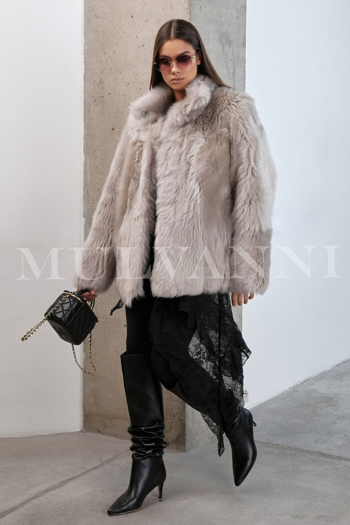 Shearling coat worn by a woman exudes timeless sophistication, with its rich texture and tailored fit offering both style and warmth.