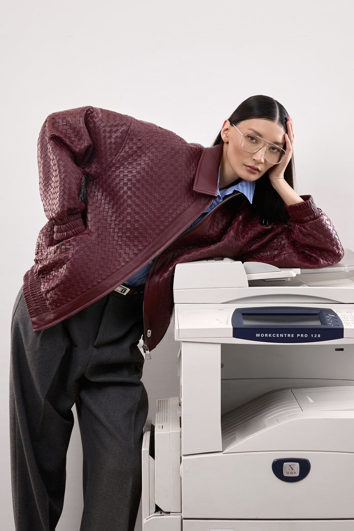 A woman dressed in a relaxed-fit burgundy bomber jacket, styled casually with subtle tailoring for a polished daily outfit.
