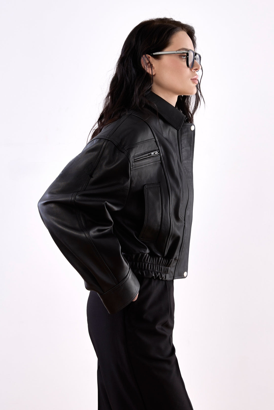 A woman dressed in a sleek cropped bomber jacket in ultra-soft genuine leather, showcasing a modern, waist-high silhouette that combines contemporary style with classic elegance.