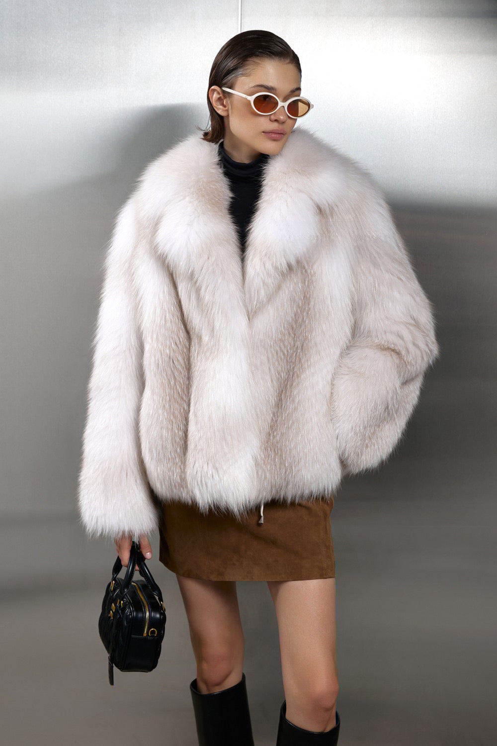 A woman wears an elegant Crossed Fox Fur coat with a plush texture and radiant sheen, perfect for extreme winter conditions down to -25ºC.