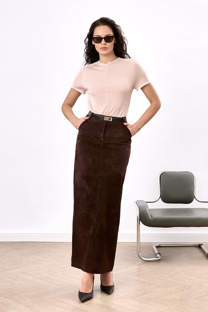 A woman wearing a chic, high-waisted brown suede pencil skirt, tailored from buttery-soft suede and falling just below the ankle for a sleek, elongated silhouette.