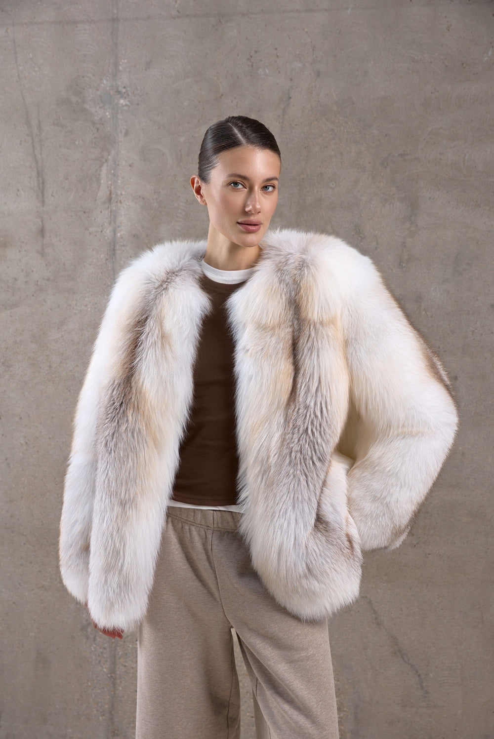 Wrapped in a voluminous genuine fox fur coat, a woman showcases rich golden hues and supreme warmth, ideal for -25ºC winter conditions.