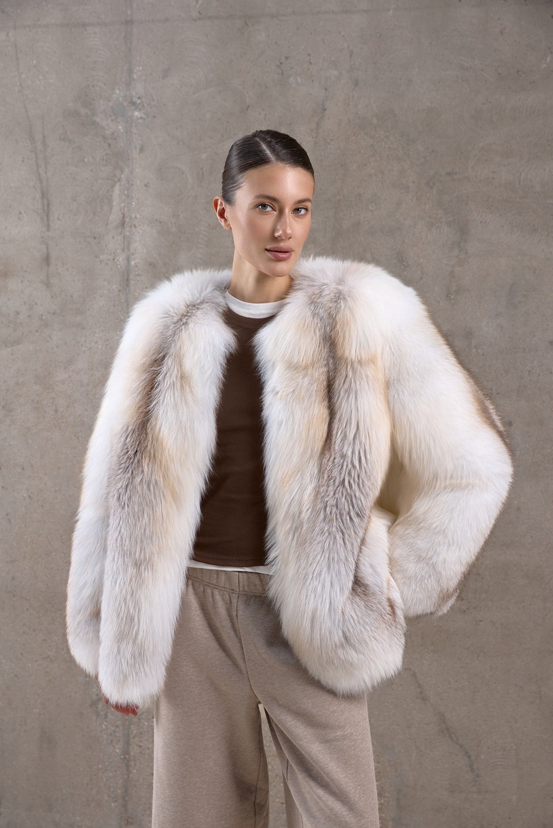 Wrapped in a voluminous genuine fox fur coat, a woman showcases rich golden hues and supreme warmth, ideal for -25ºC winter conditions.