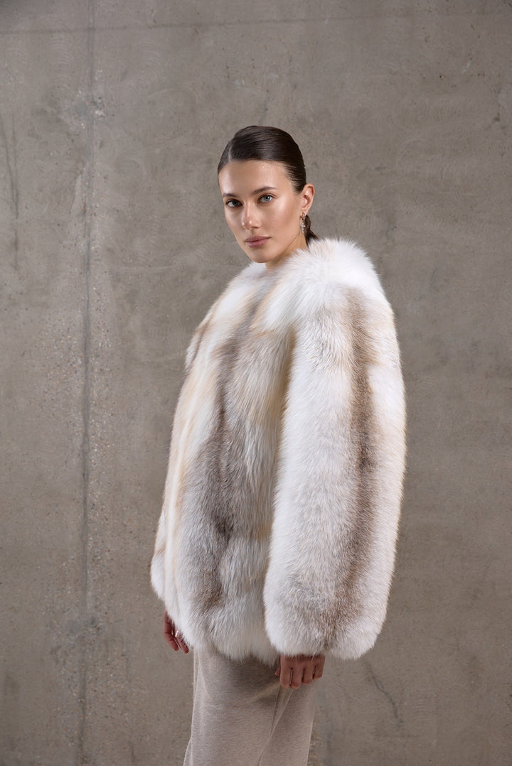 Dressed in a golden-hued fox fur coat with dense, natural texture, a woman blends timeless elegance with maximum winter protection.