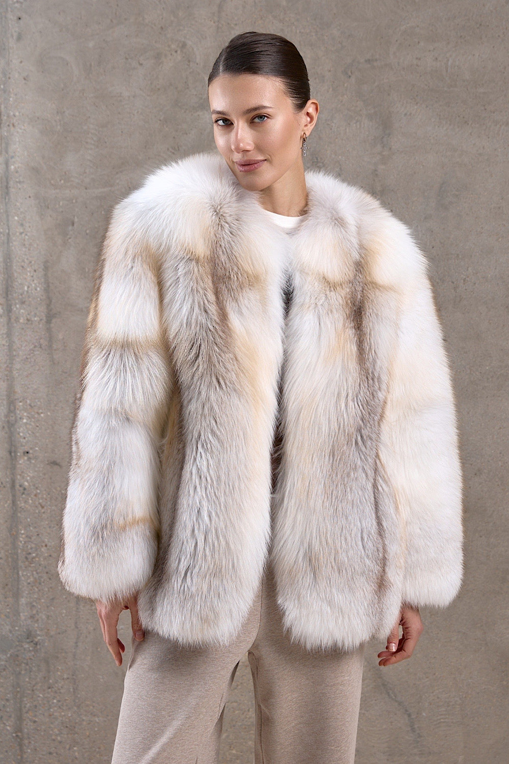 A woman is wearing a stunning gold crossed fox fur coat with a full pelt design, radiating glamour and built to withstand freezing arctic temperatures.