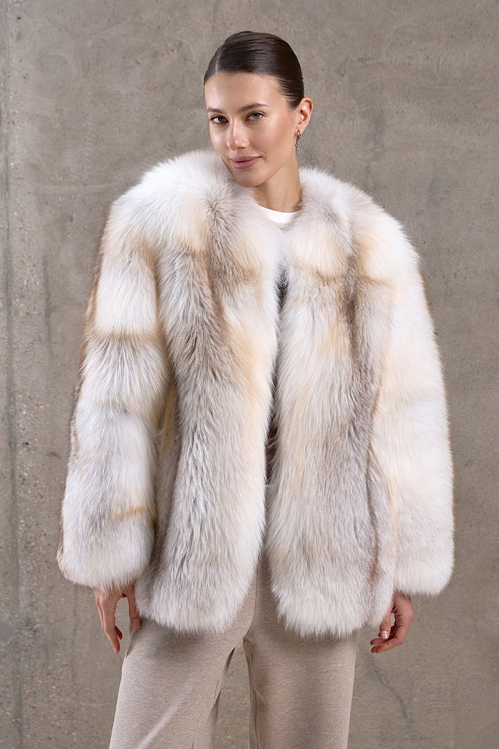 A woman is wearing a stunning gold crossed fox fur coat with a full pelt design, radiating glamour and built to withstand freezing arctic temperatures.