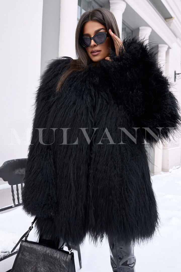 A woman in a trendy black Mongolian fur coat, characterized by its rich, fluffy fabric and contemporary cut. The coat provides warmth and style, making it an ideal choice for chilly days in fall and winter.