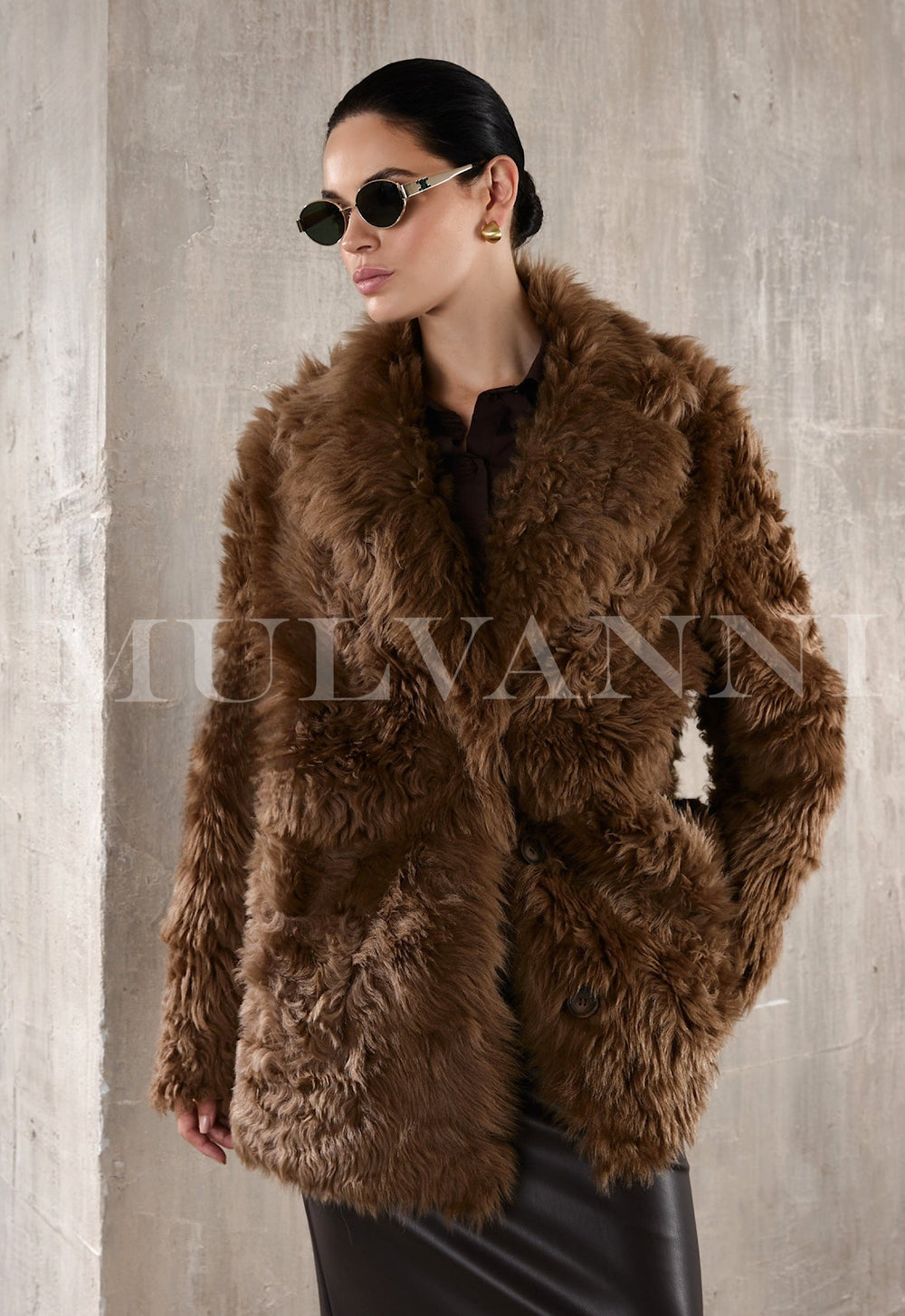 Elegantly dressed woman modeling a premium chestnut shearling coat, radiating warmth and sophisticated style with its plush texture and refined silhouette.