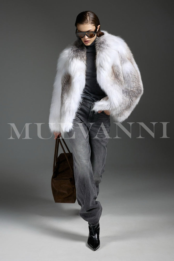 Woman draped in plush Arctic Crossed Fox Fur carries a brown suede bag, effortlessly blending elegance with earthy tones.