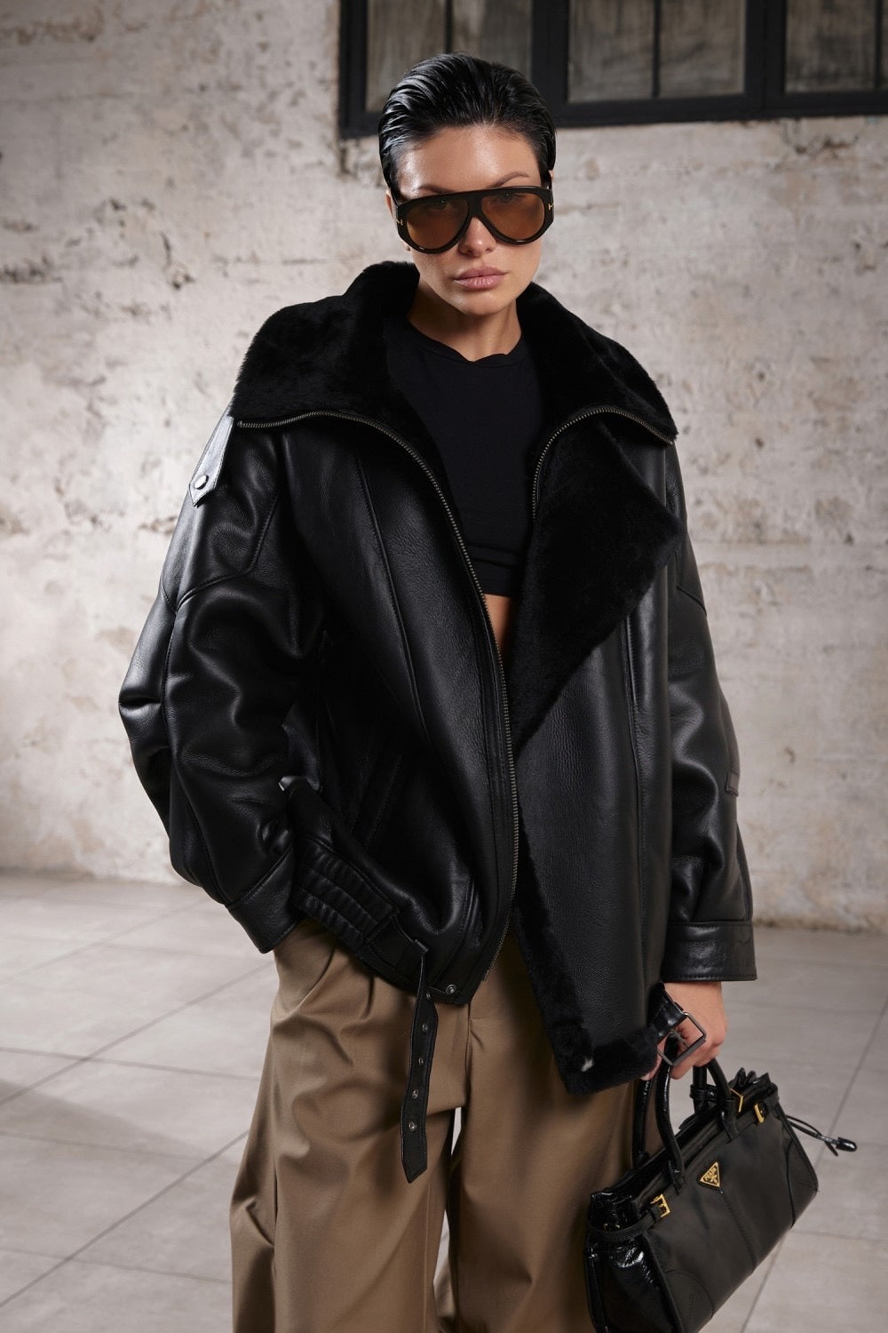 A woman models a chic oversized sheepskin jacket, styled with a high neckline, relaxed silhouette, and soft shearling interior for a cozy yet elevated everyday look.
