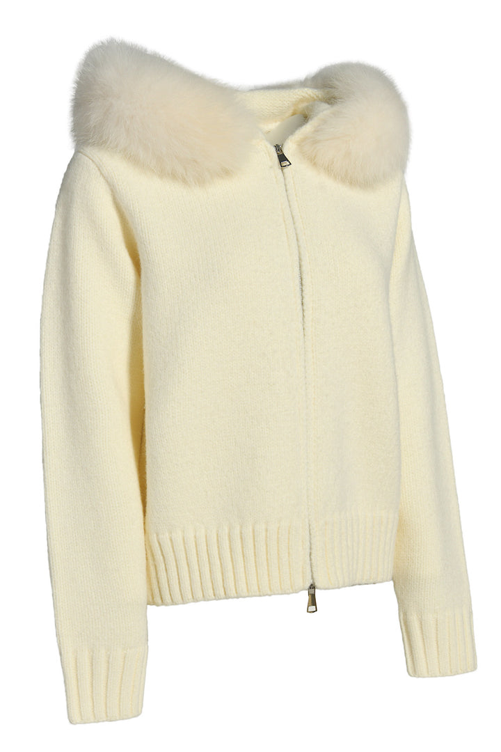 Chic ivory cashmere outerwear with matching fox fur, combining comfort and understated luxury. 