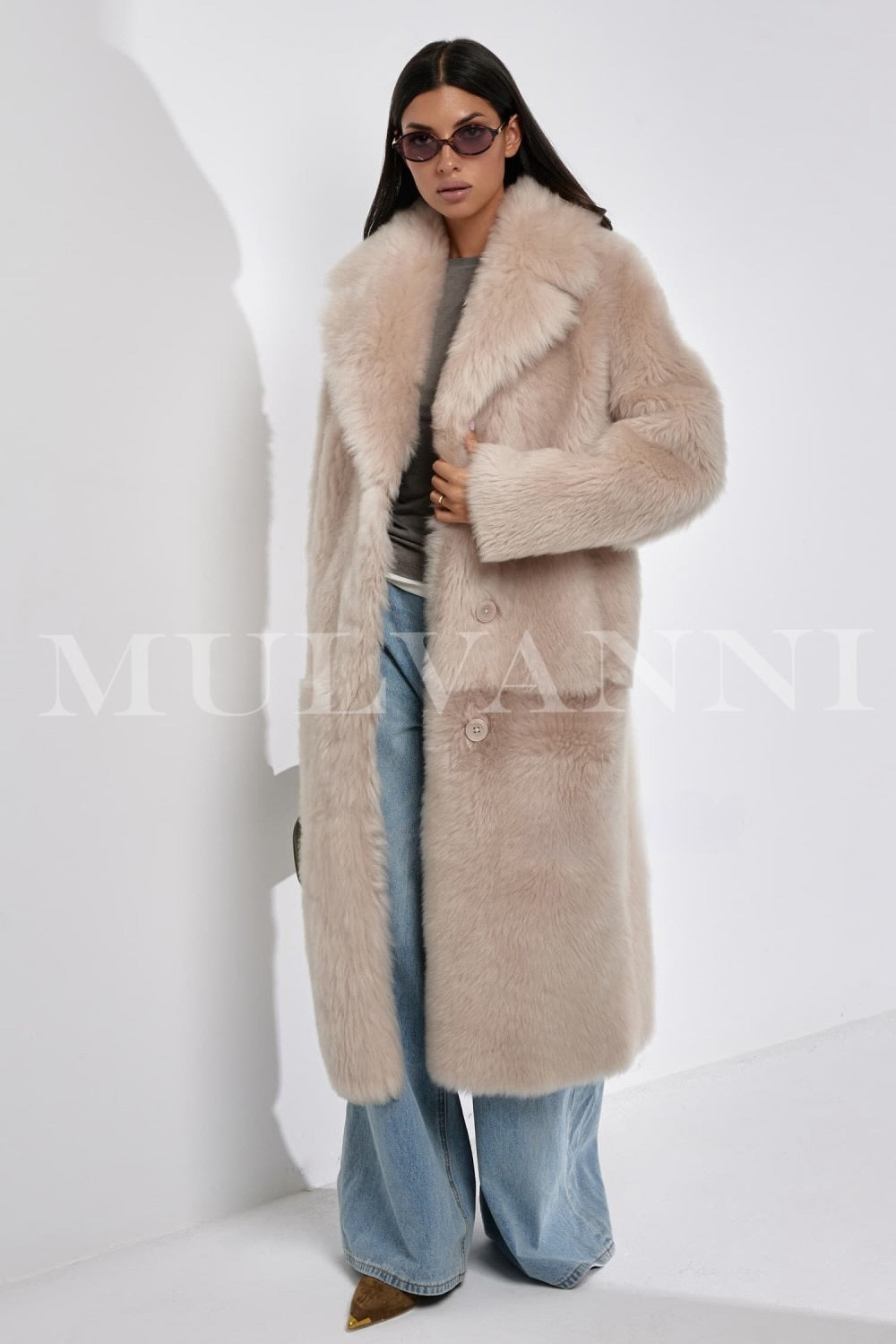Styled in a full-length genuine shearling coat, the woman exudes timeless elegance and warmth with soft texture and insulating comfort.
