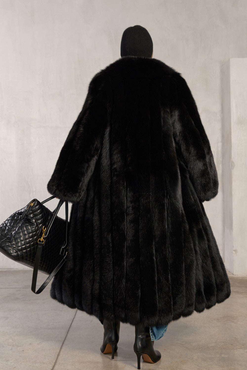 Chic winter look featuring a woman in a voluminous black fox fur coat with a timeless silhouette.