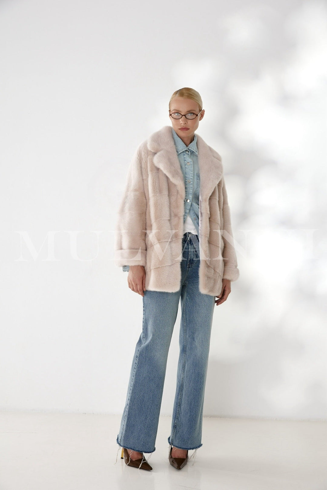 Wearing this handcrafted mink coat, the woman exudes classic sophistication, blending luxurious softness with a sleek satin inner lining.