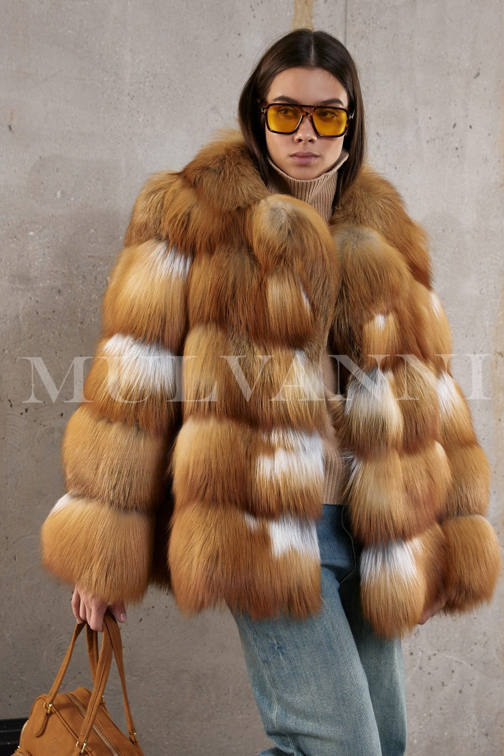 Woman elegantly styled in a voluminous red fox fur coat paired with denim jeans, blending luxury with casual winter chic.