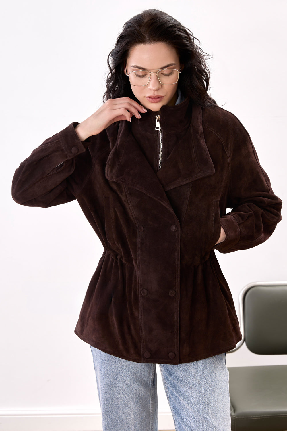 A stylish woman dressed in the dark brown Suede Leather Jacket, featuring a luxurious suede finish, high neckline, and comfortable relaxed fit for a sporty yet sophisticated look.
