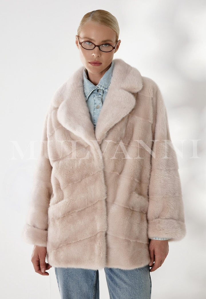 A woman wears this exquisite mink coat, handcrafted by artisans, radiating timeless glamour and warmth with its pure mink fur and luxurious satin lining.