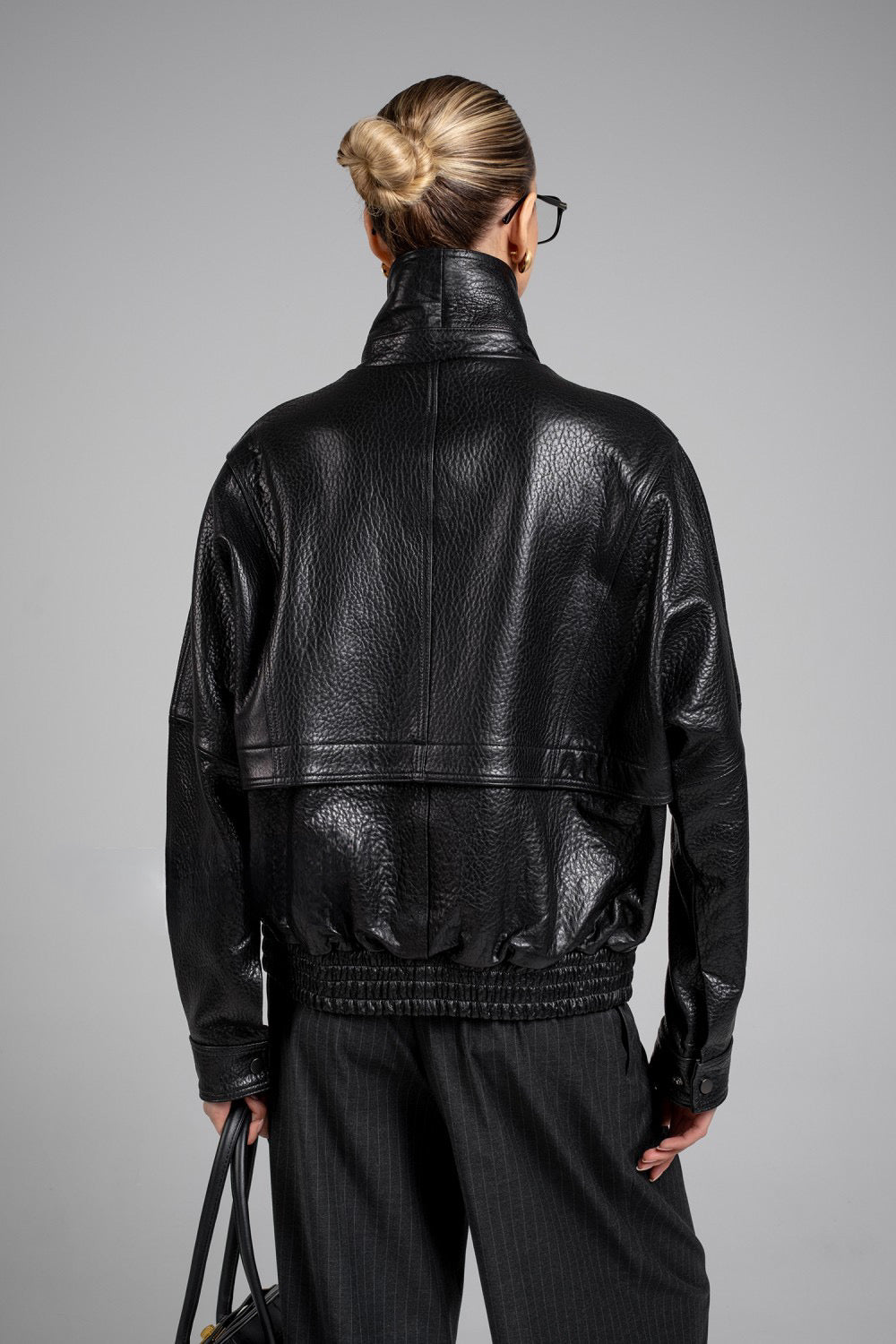 Sophisticated woman in black genuine leather jacket, combining timeless outerwear with a contemporary fit.