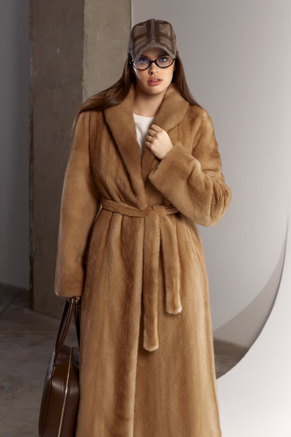 Elegant and refined, a woman is draped in a genuine mink fur coat that flows gracefully to the ankles, radiating classic luxury.