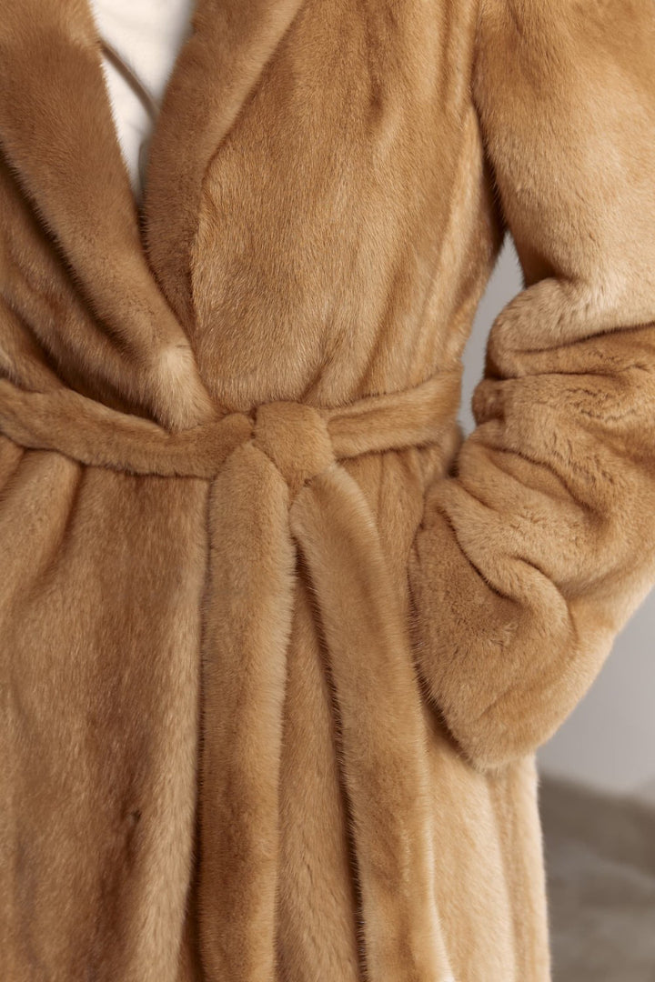 Wrapped in opulence, a woman wears a rich-toned mink coat, its fluid silhouette and natural shine capturing winter glamour.