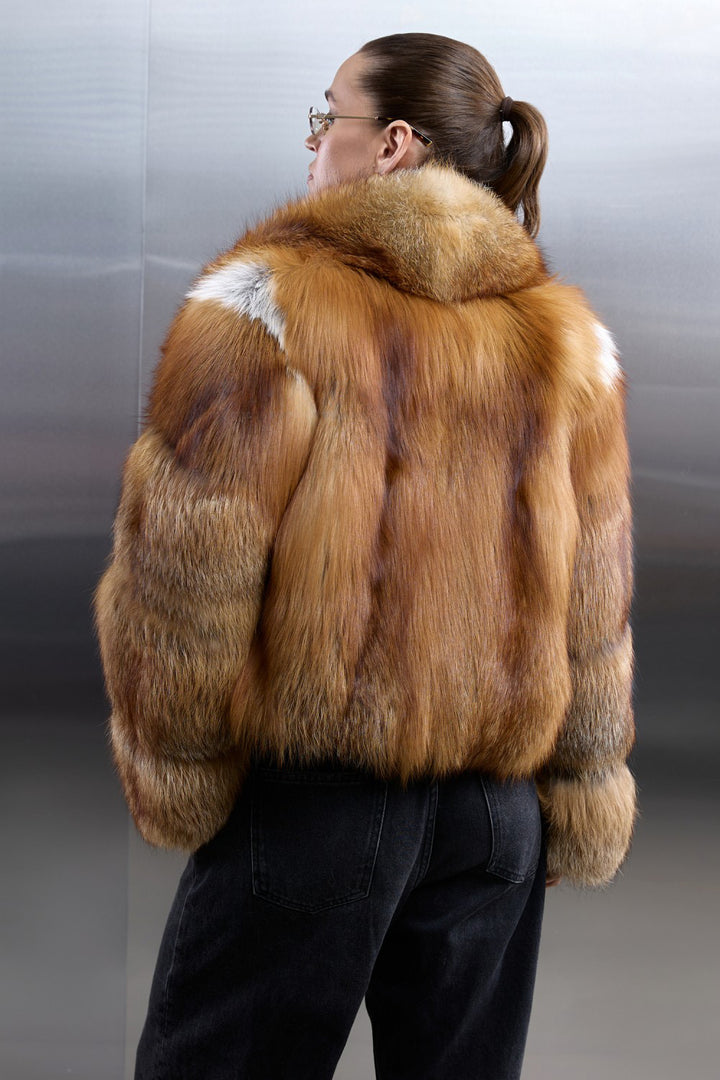 Elegant woman wearing a full red fox fur coat with a velvety texture and striking color gradient, perfect for arctic temperatures.