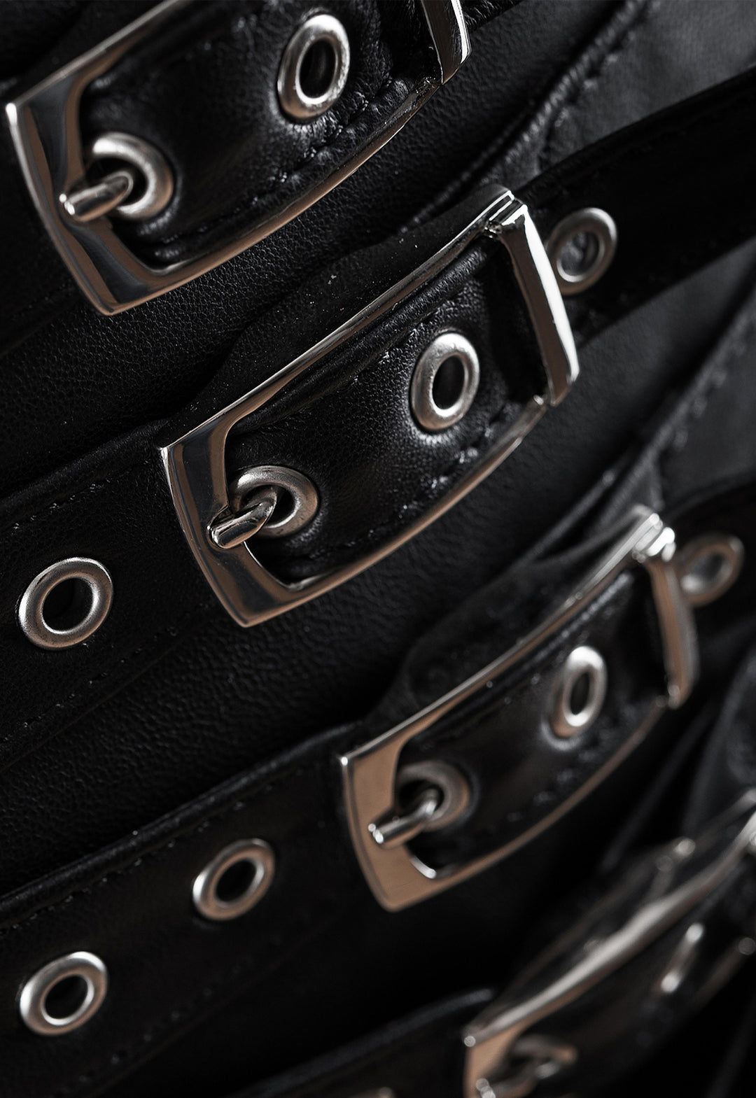 Structured leather skirt crafted from premium genuine leather, accented with striking straps and buckles for a sophisticated, modern look.