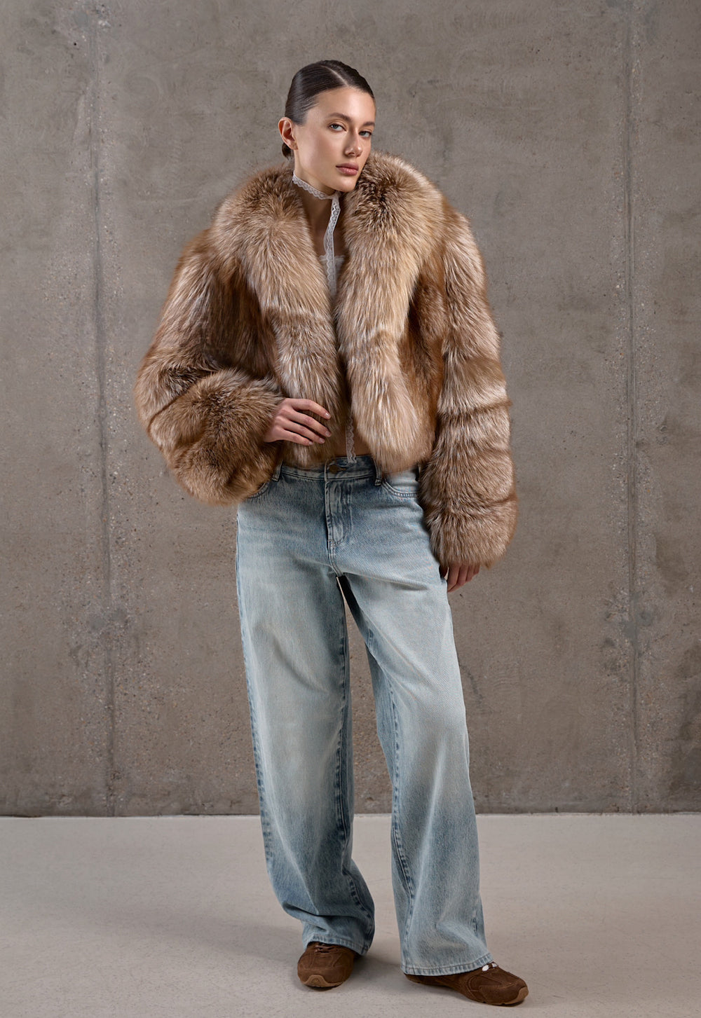 Dressed in jeans and a rich brown mixed-tone fox fur coat, a woman showcases a stylish and cozy look perfect for arctic temperatures.