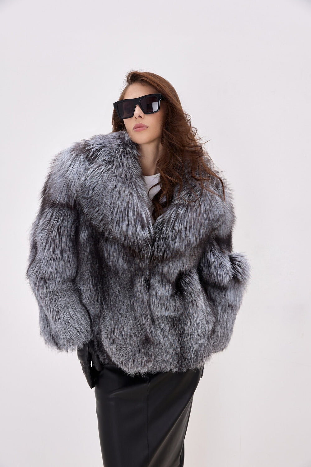 Stylish winter look with a woman in a plush Silver Fox Fur Coat and black leather gloves, featuring long sleeves, side slit pockets, and refined closures.