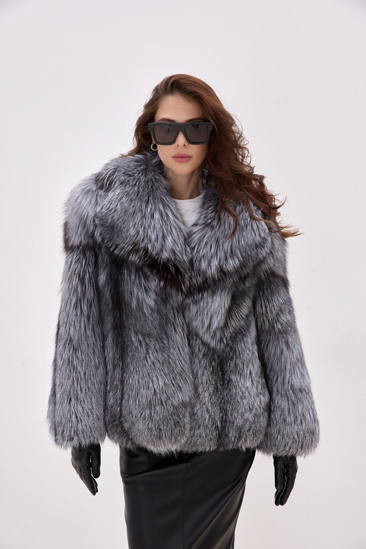 Woman wears a voluminous Silver Fox Fur Coat paired with sleek black leather gloves, showcasing an elegant winter ensemble with full-pelt construction and luxurious texture.