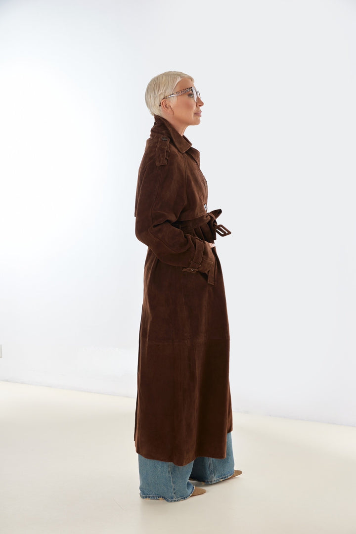 A plus size woman dressed in a chocolate brown suede trench coat with structured tailoring and a soft, luxurious texture that combines comfort with timeless style.