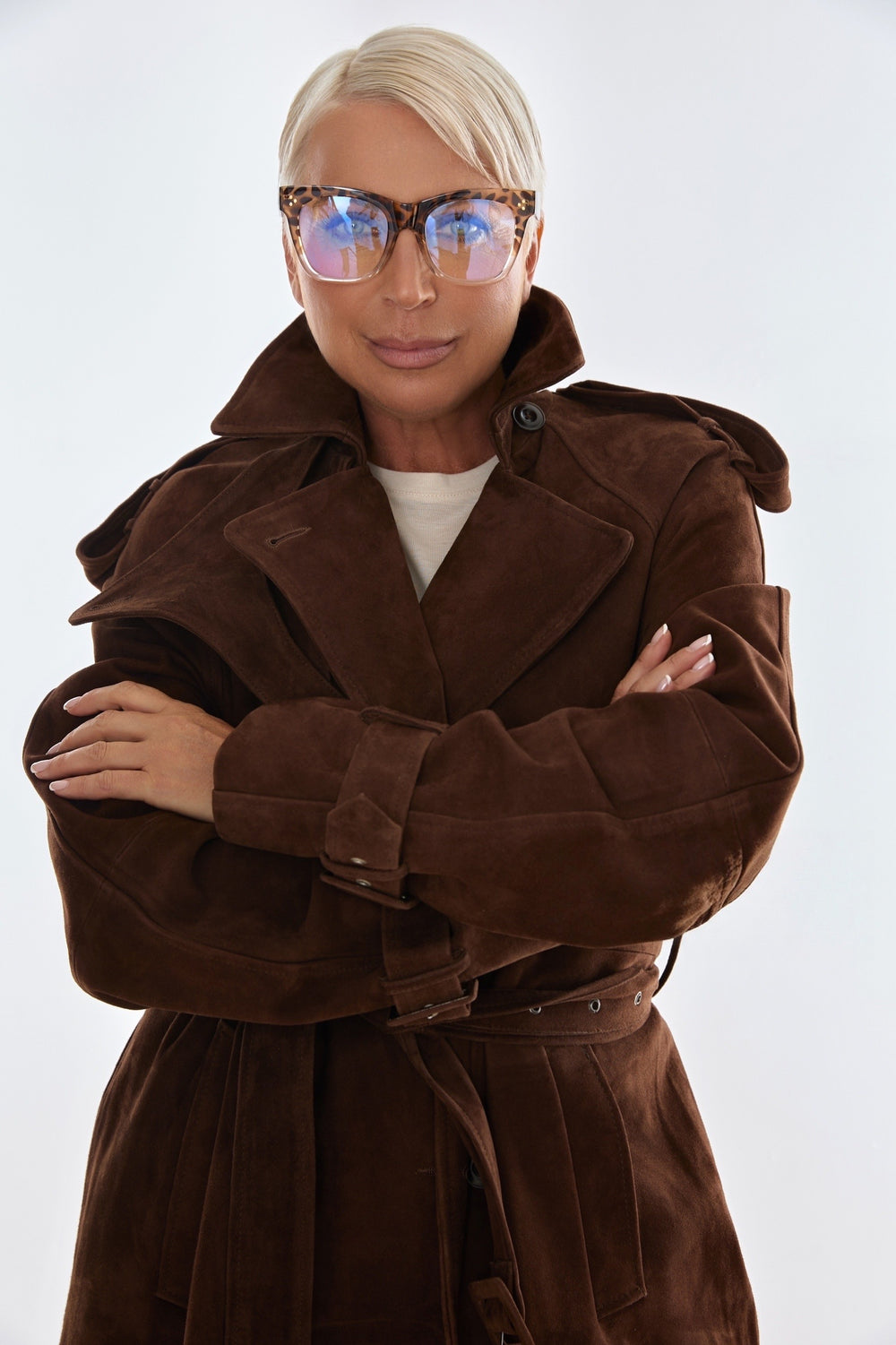 A plus size woman models a rich chocolate brown suede trench coat, crafted from high-quality leather with a classic double-breasted design and refined silhouette.