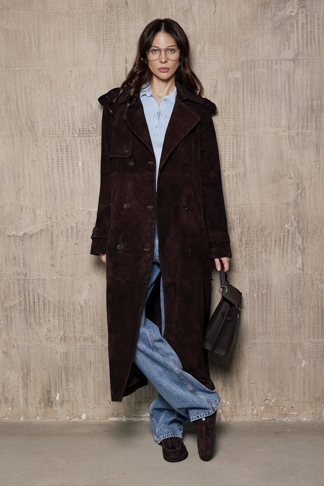 A woman dressed in a high-quality brown suede leather trench coat, combining timeless tailoring with modern elegance and comfort for layering.
