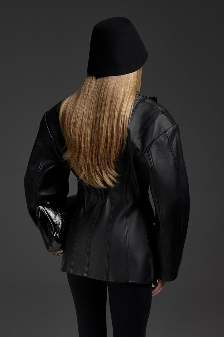 A woman wearing a chic black leather blazer with a cinched waist, combining soft, high-quality leather with a tailored silhouette for a timeless and versatile wardrobe piece.