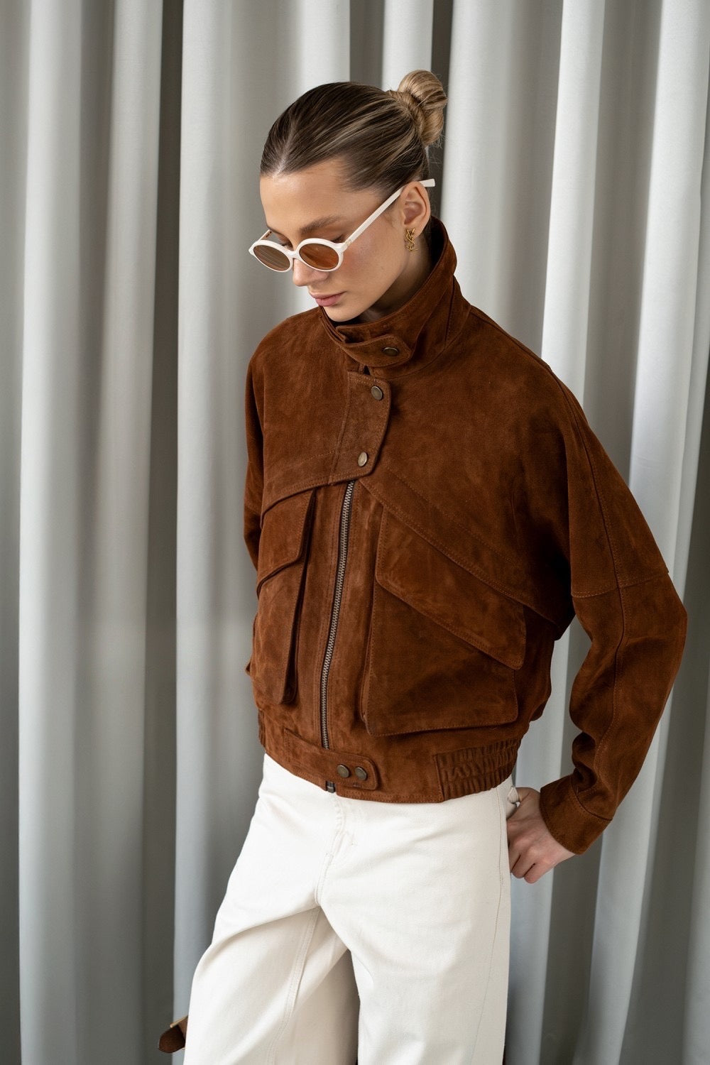 Model wearing a rich brown suede jacket with statement pockets, combining soft texture with elevated everyday style.