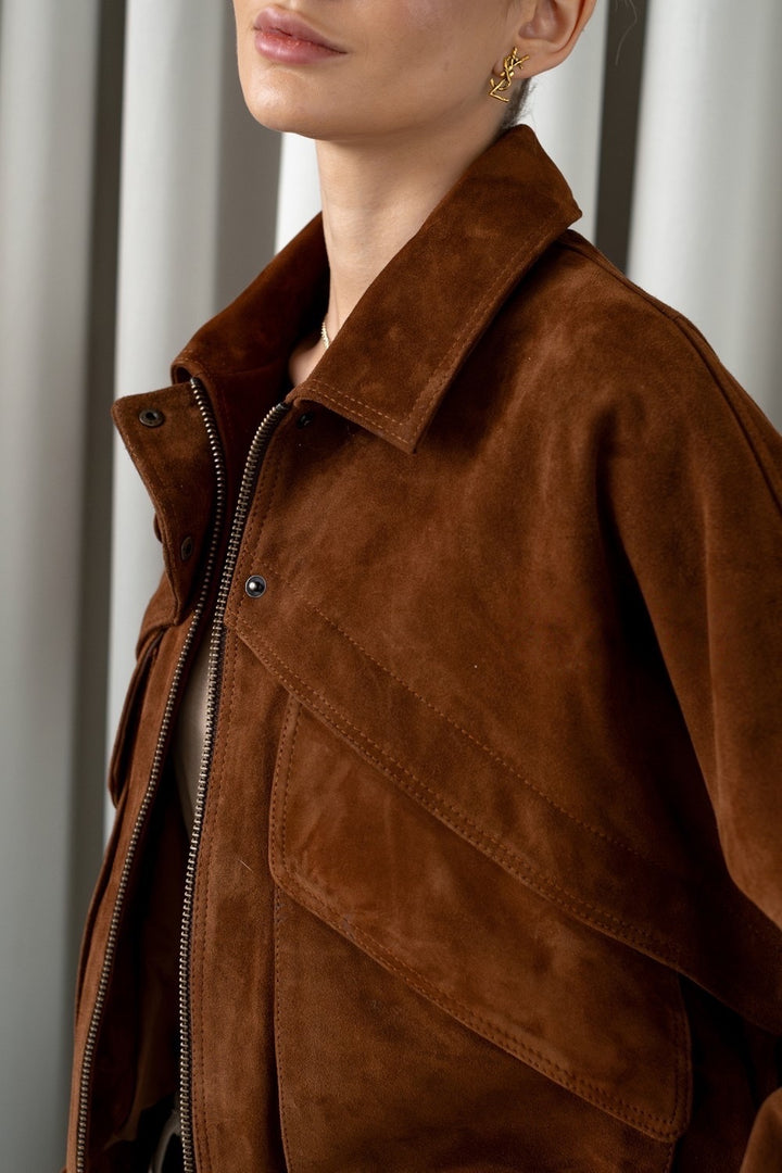 Brown suede outerwear styled effortlessly with neutral trousers and accessories, reflecting quiet luxury and refined fashion.