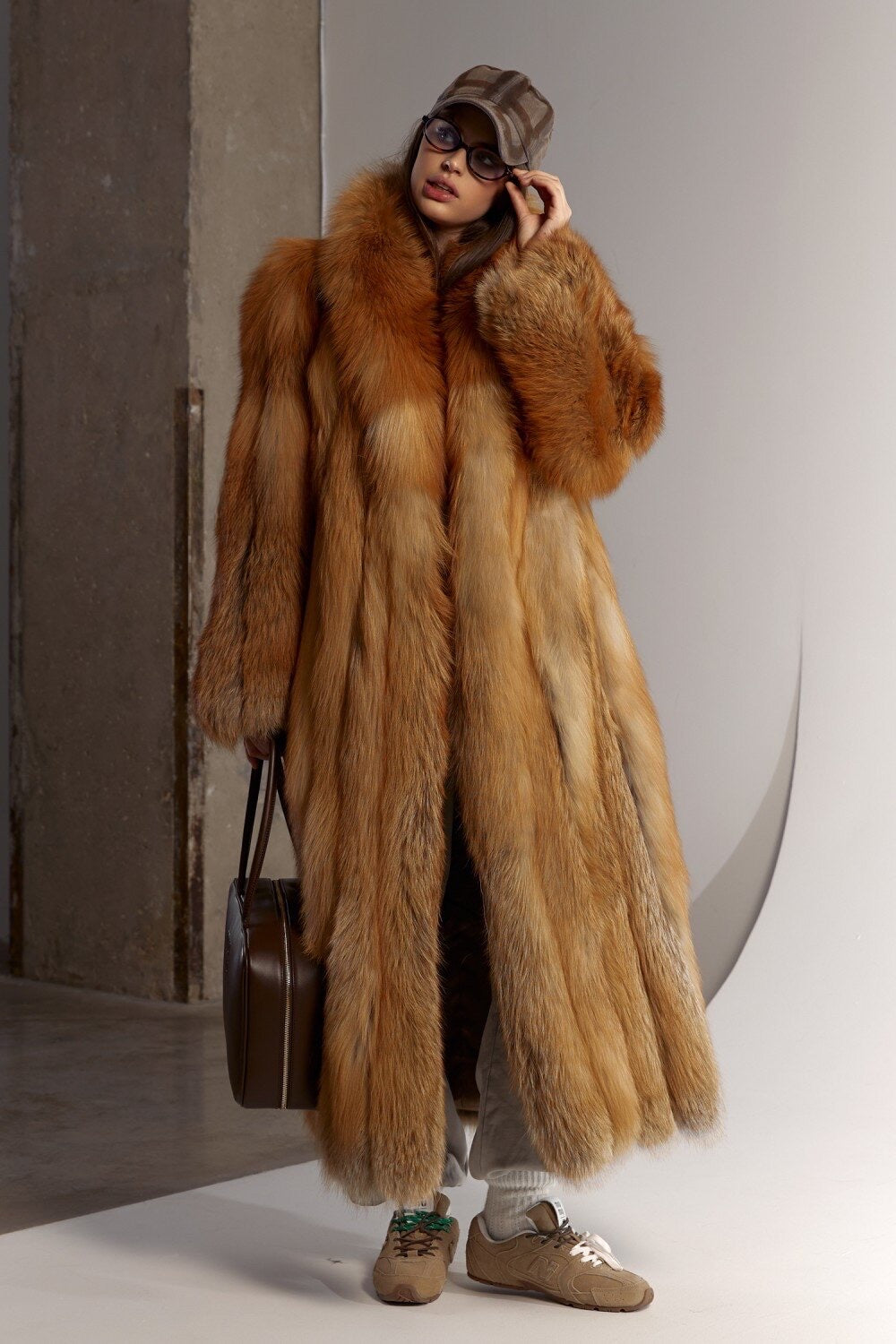 A woman wears a luxurious red fox fur coat styled sporty and chic, its soft, dense fur and sleek 130cm length offering warmth and elegance during cold winter days.