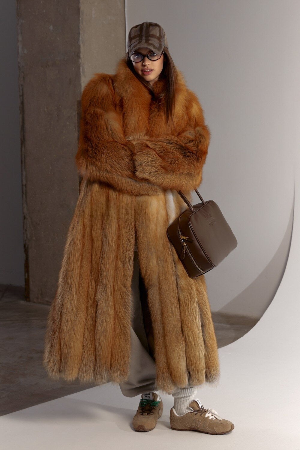 Woman styled in a red fox fur coat with a sporty edge, featuring plush fur and a flattering longline fit that balances glamour and practicality in freezing temperatures.