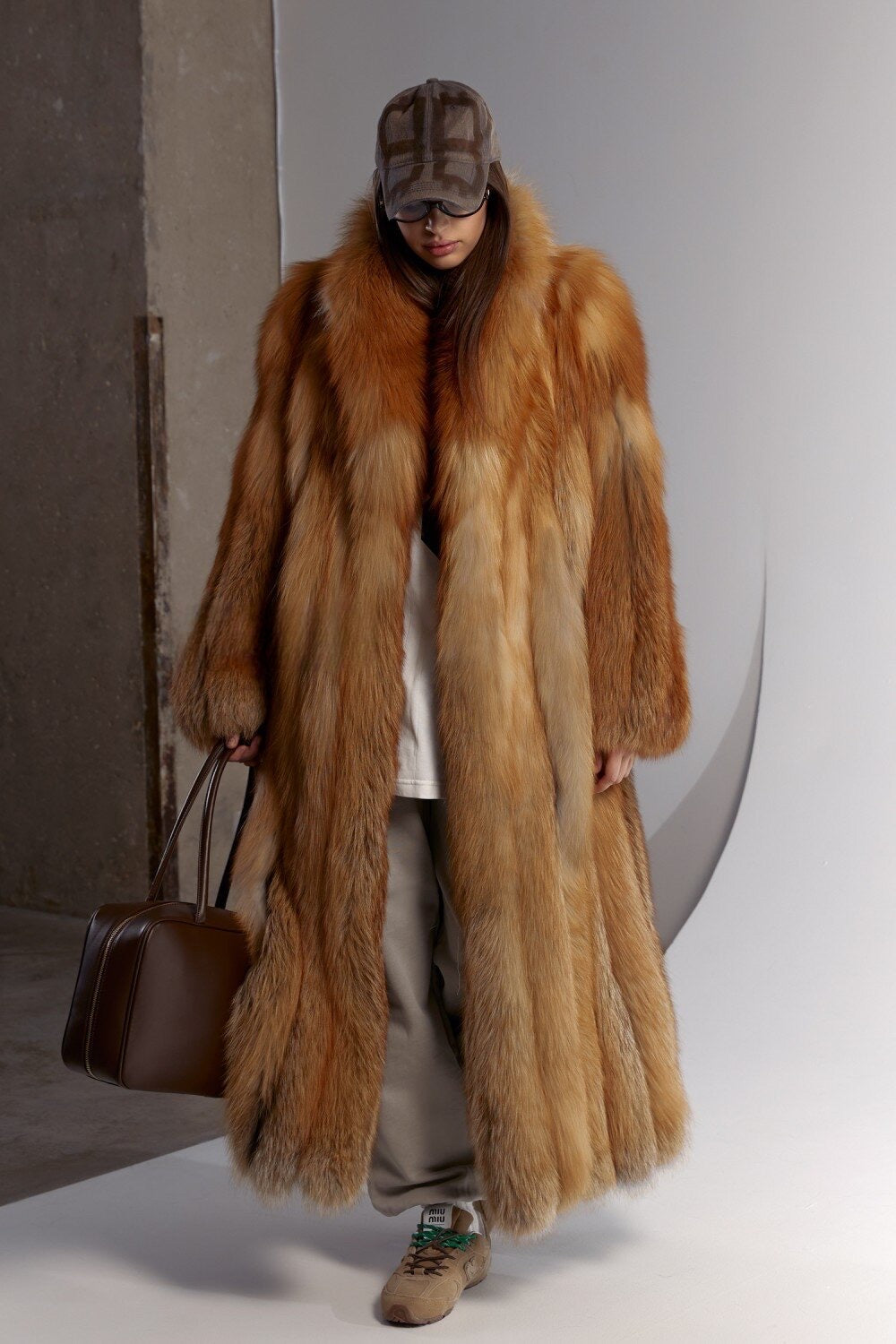 A woman confidently wears a sporty, elegant red fox fur coat, its luxurious texture and tailored silhouette providing both comfort and fashion-forward winter coverage.