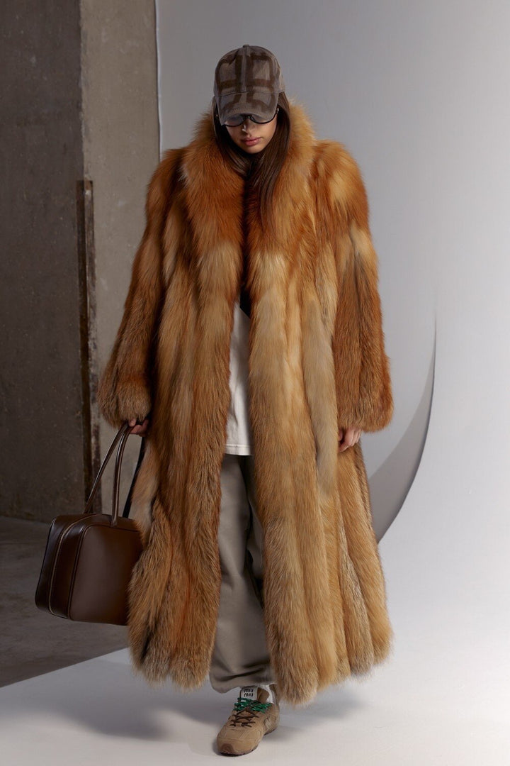 A woman confidently wears a sporty, elegant red fox fur coat, its luxurious texture and tailored silhouette providing both comfort and fashion-forward winter coverage.