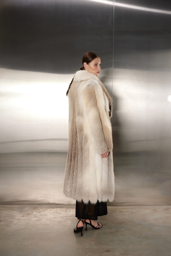 The woman’s luxurious gold fox fur coat glows with a rich, golden hue, its sumptuous softness and classic cut creating a refined and polished winter look.