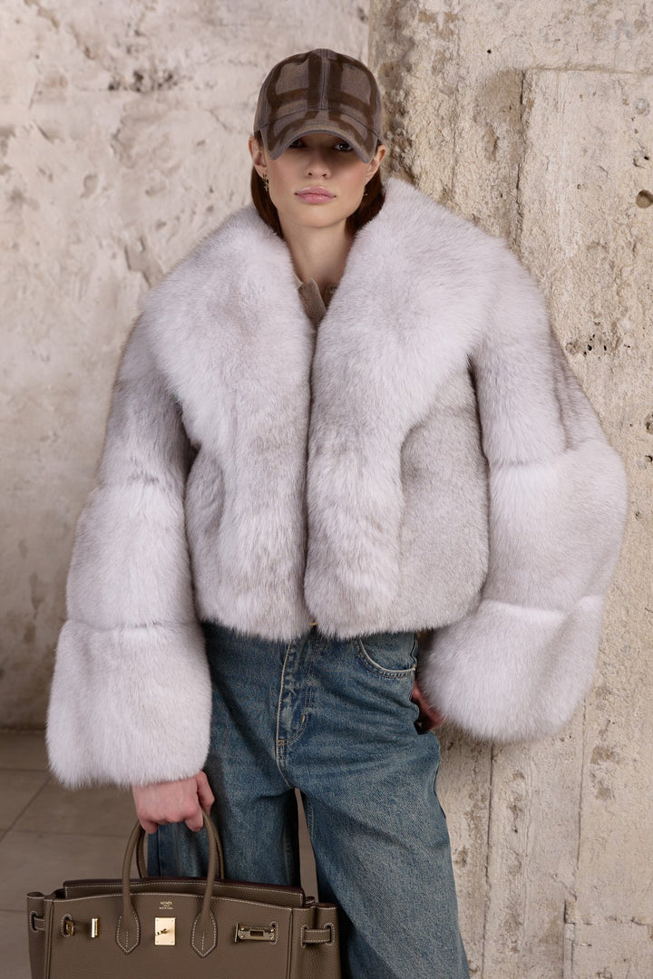 A woman is seen wearing a natural-toned Fox Fur coat that combines plush texture with refined warmth, perfect for harsh winter conditions.