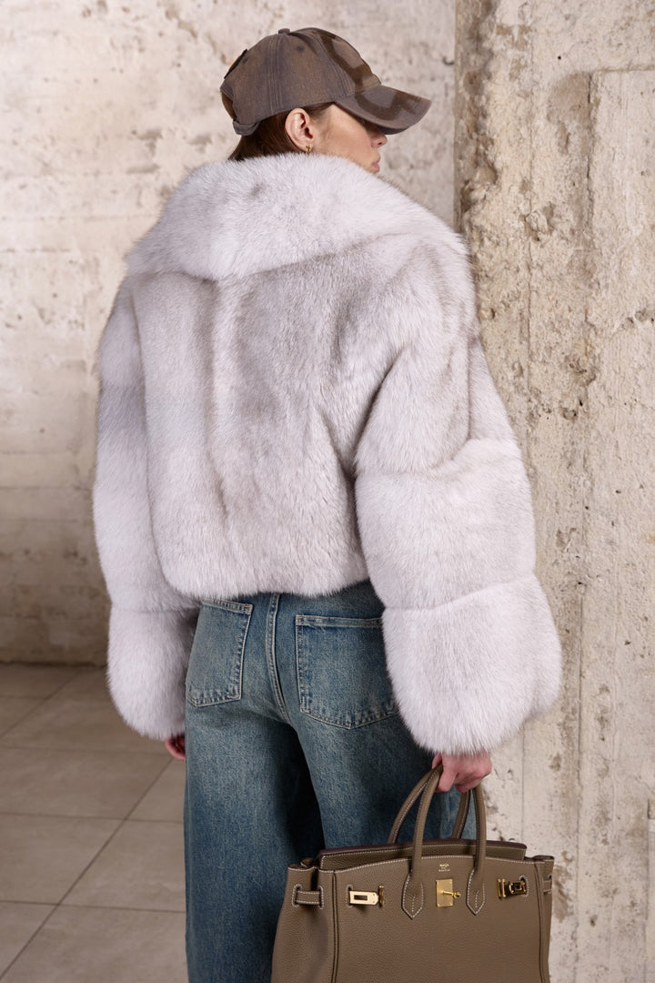 Draped in a soft, voluminous short Fox Fur coat, a woman showcases effortless elegance and protection against extreme cold weather.