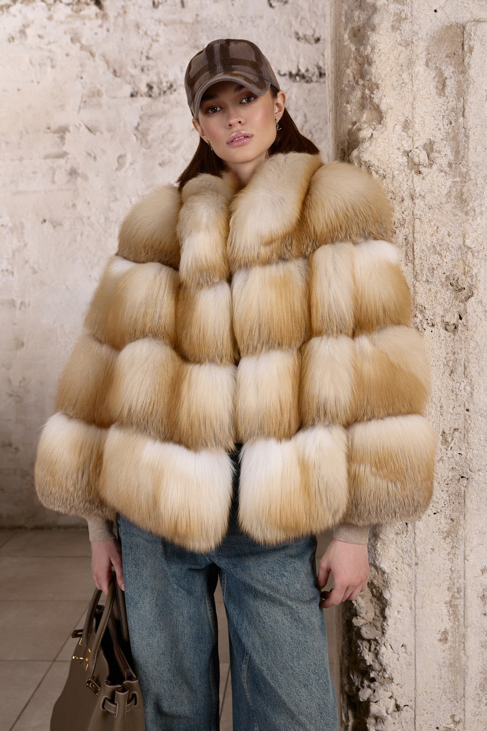 A woman wears a luxurious Gold Fox Fur Coat paired with jeans, showcasing a striking blend of fiery natural hues and casual elegance.